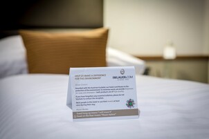 Een hotelbed met een bordje over handdoekgebruik.