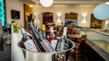Uma área de bar com um balde de metal contendo várias garrafas de vinho.