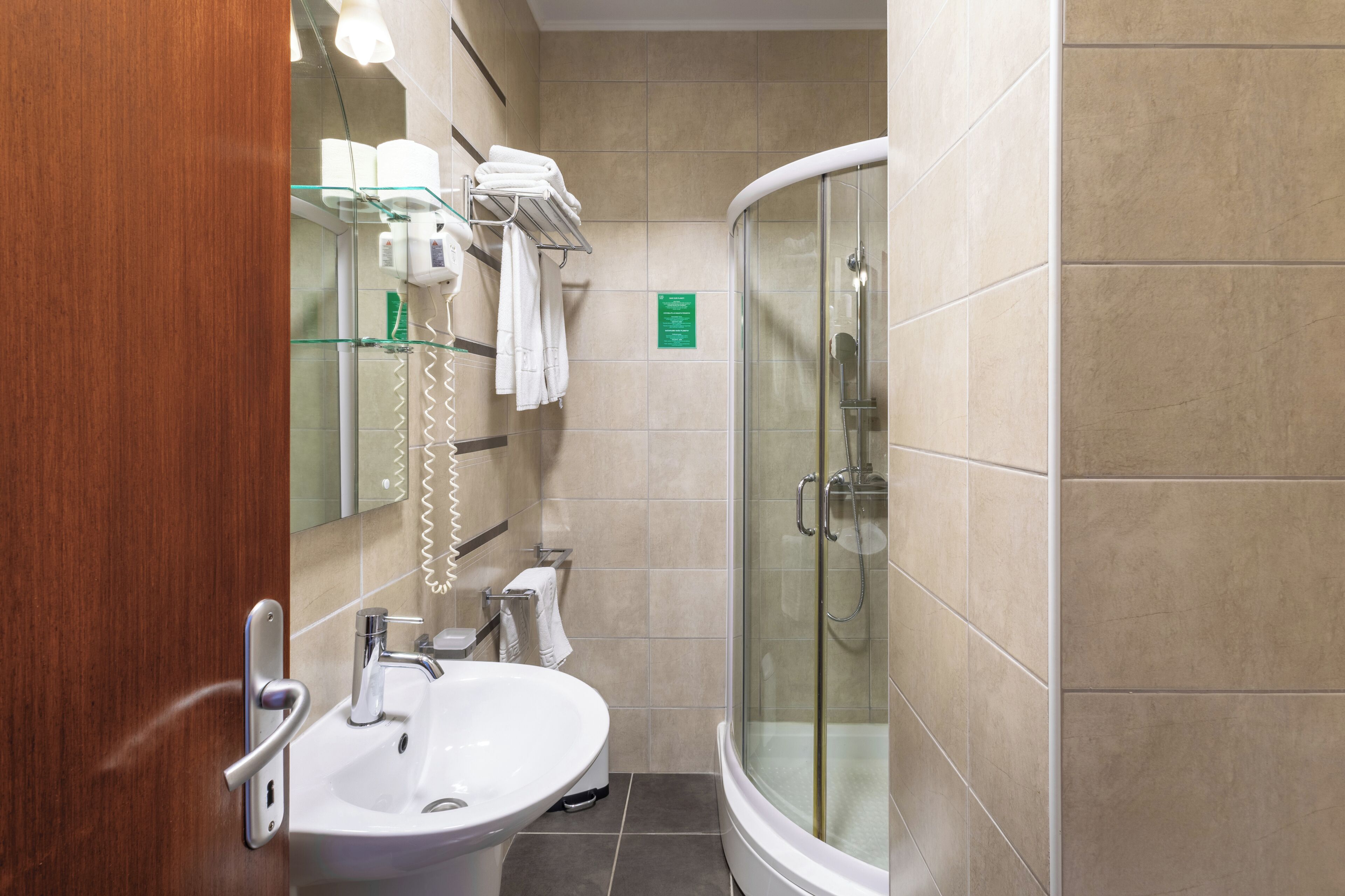 A modern bathroom with a glass-enclosed shower, a sink, and a towel rack.