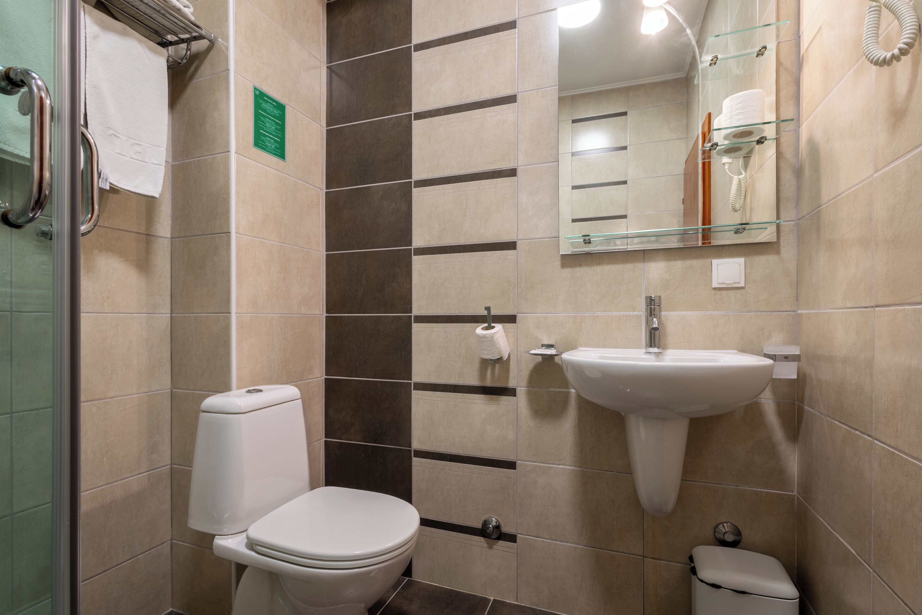 A modern bathroom with a toilet, sink, and mirror.