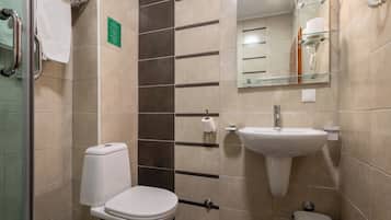 A modern bathroom with a toilet, sink, and mirror.