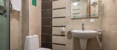 A modern bathroom with a toilet, sink, and mirror.