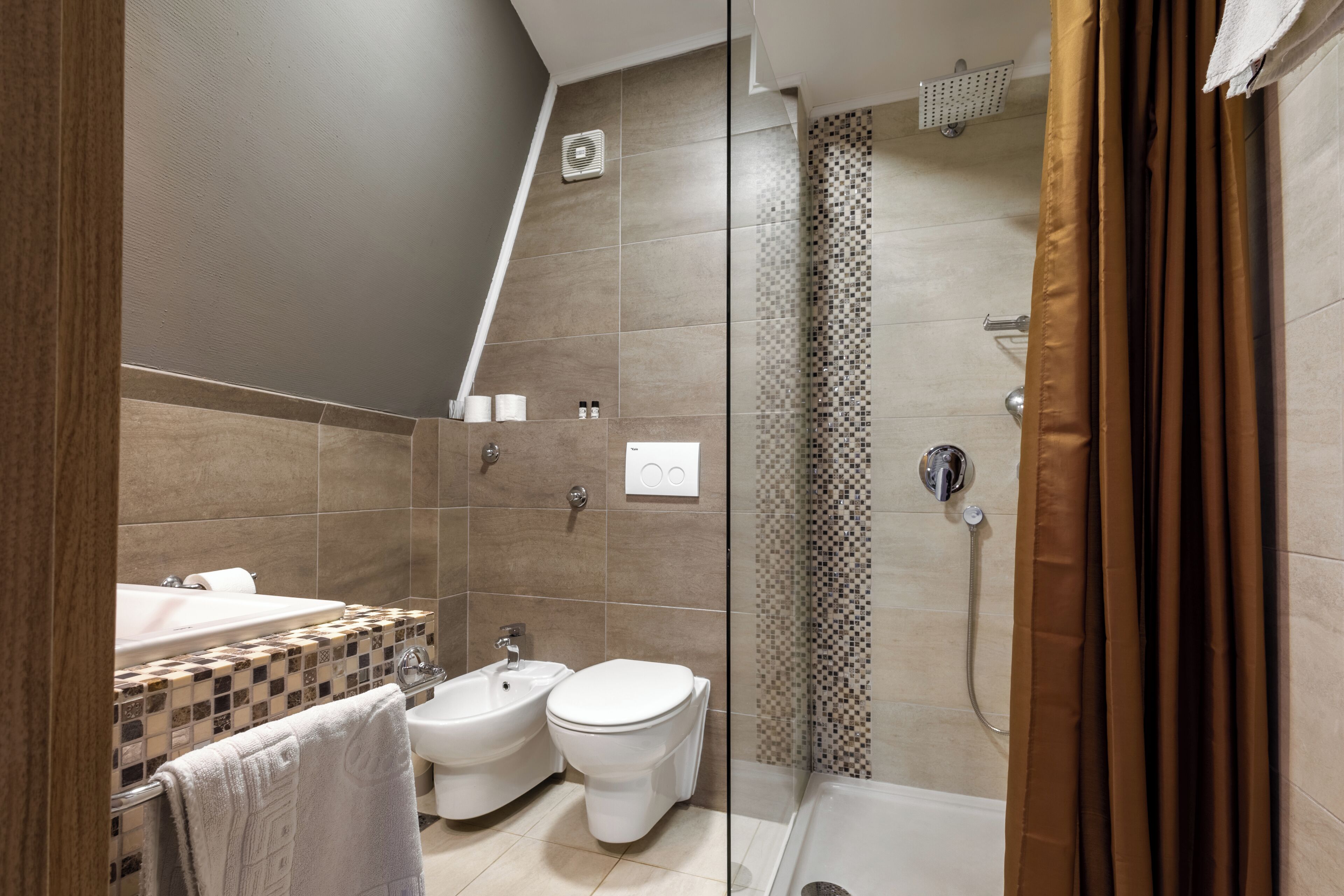 Un baño moderno con ducha, bidé e inodoro.