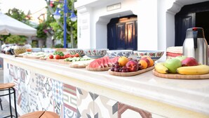 Una barra de desayuno con frutas variadas y tazones de comida.