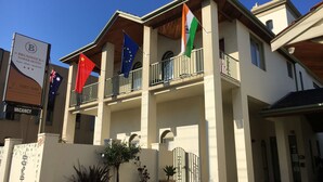 A hotel with a balcony, a signboard, and flags. - Brunswick Tower Hotel (Brunswick)