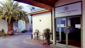 The Brunswick Tower Hotel reception with a palm tree and outdoor seating area. - Brunswick Tower Hotel (Brunswick)