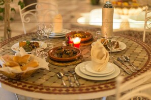 A dining table set with plates, bowls, glasses, and cutlery.