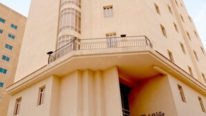 A tall, beige building with a curved corner and a balcony. The building has multiple windows and a sign that reads "LaVilla Hotel."