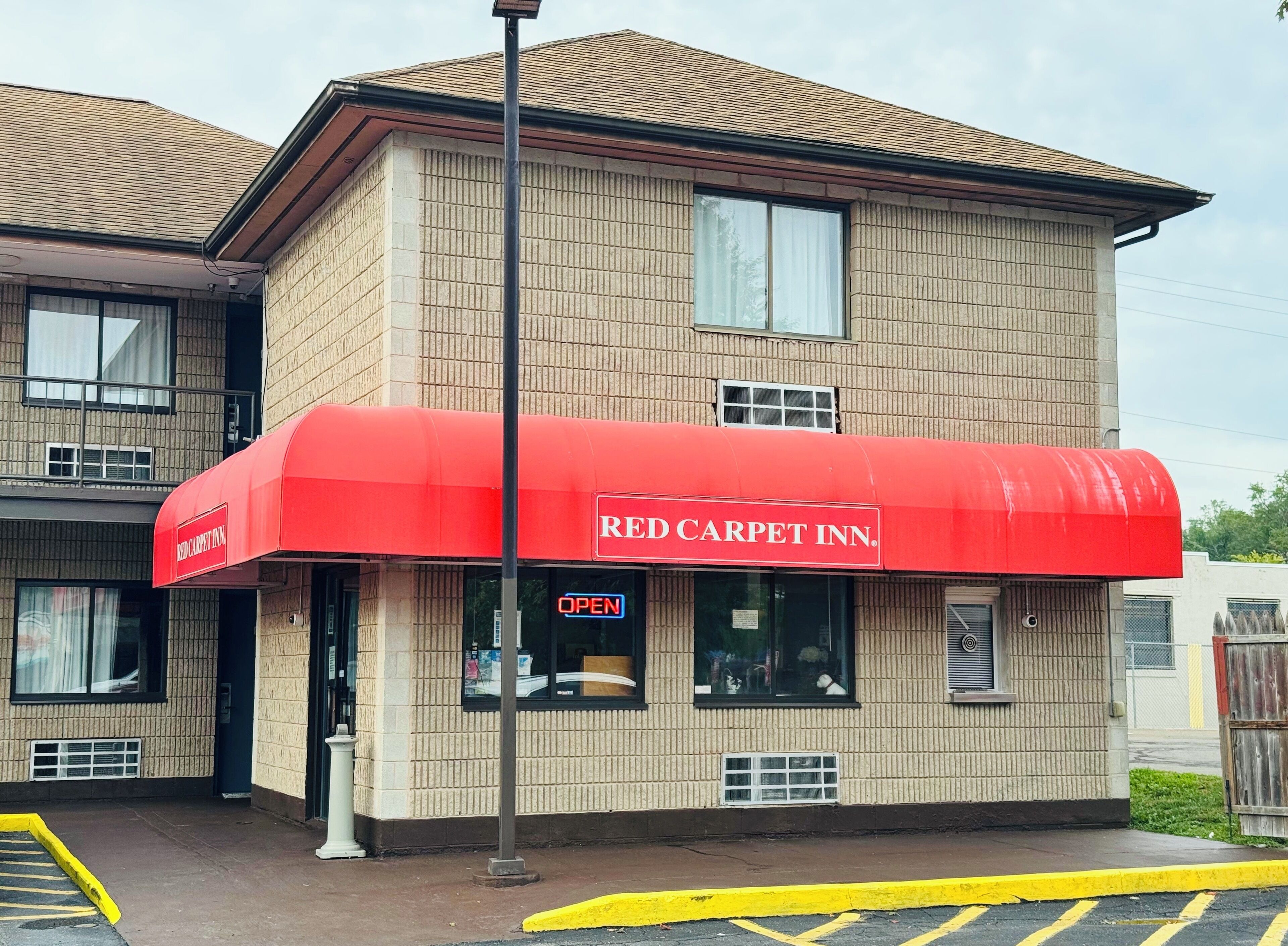 A building with a red awning labeled "RED CARPET INN."