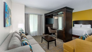 Een hotelkamer met een bank, fauteuil en een bed.