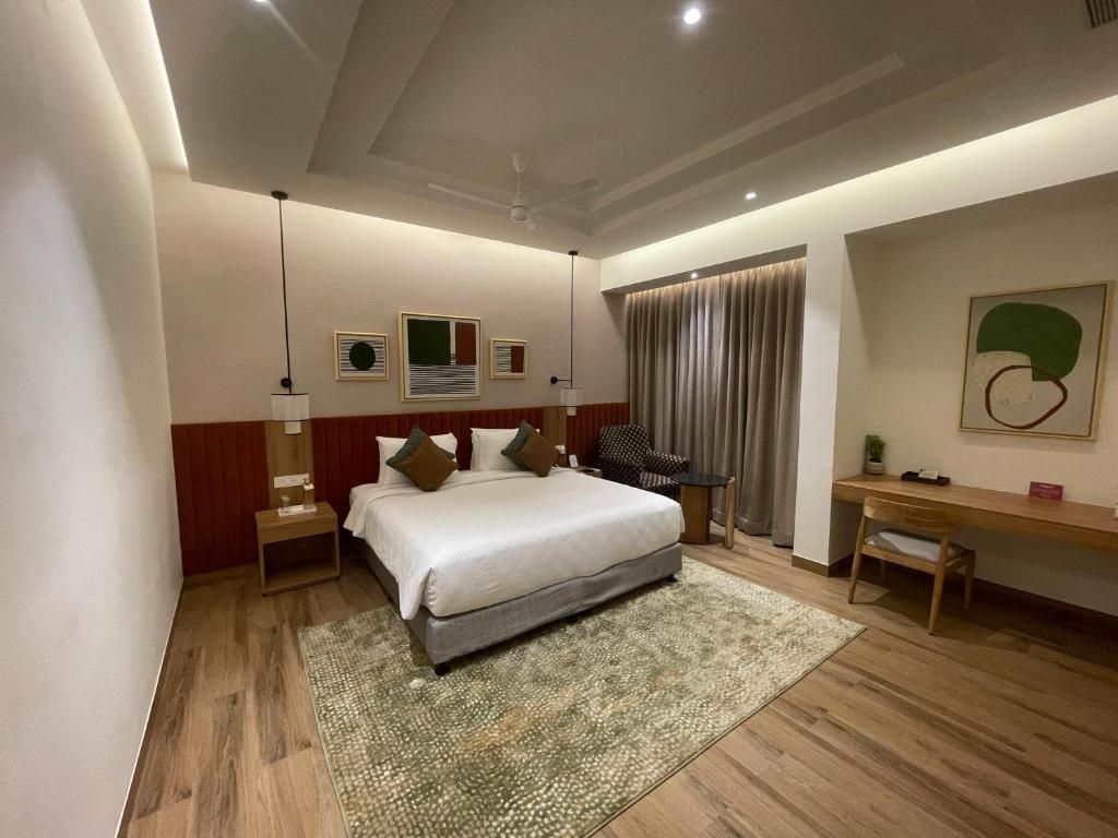 Une chambre d’hôtel moderne avec un grand lit, un bureau et une chaise.
