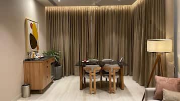 Una sala de estar moderna con una mesa de comedor, sillas, un sofá, una lámpara y un aparador.