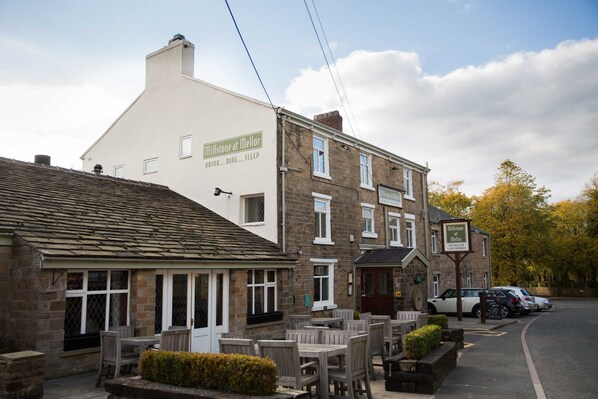 A building with a sign reading "Millstone at Mellor" and outdoor seating.