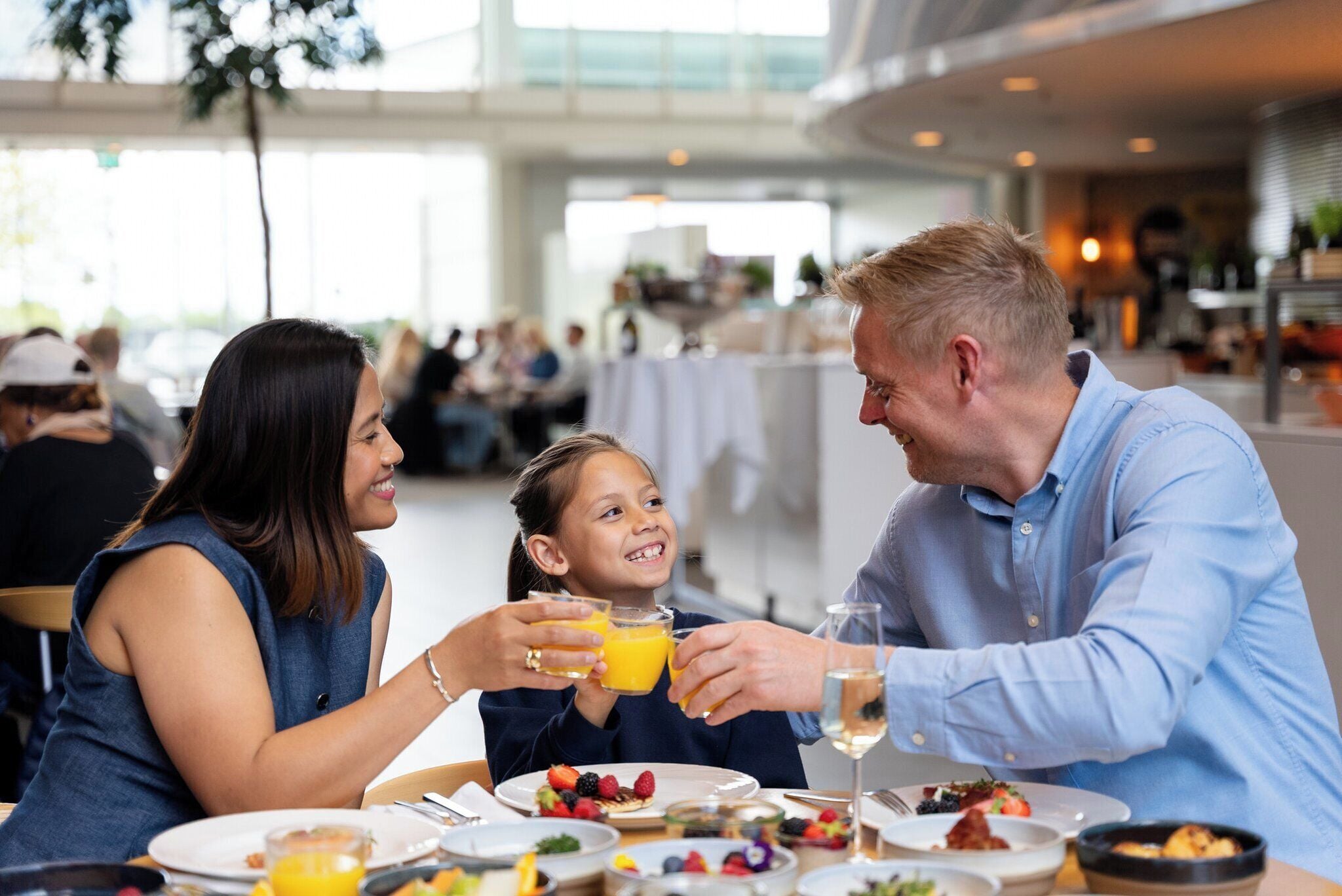 A family dining in a modern restaurant with a bright interior and large windows.