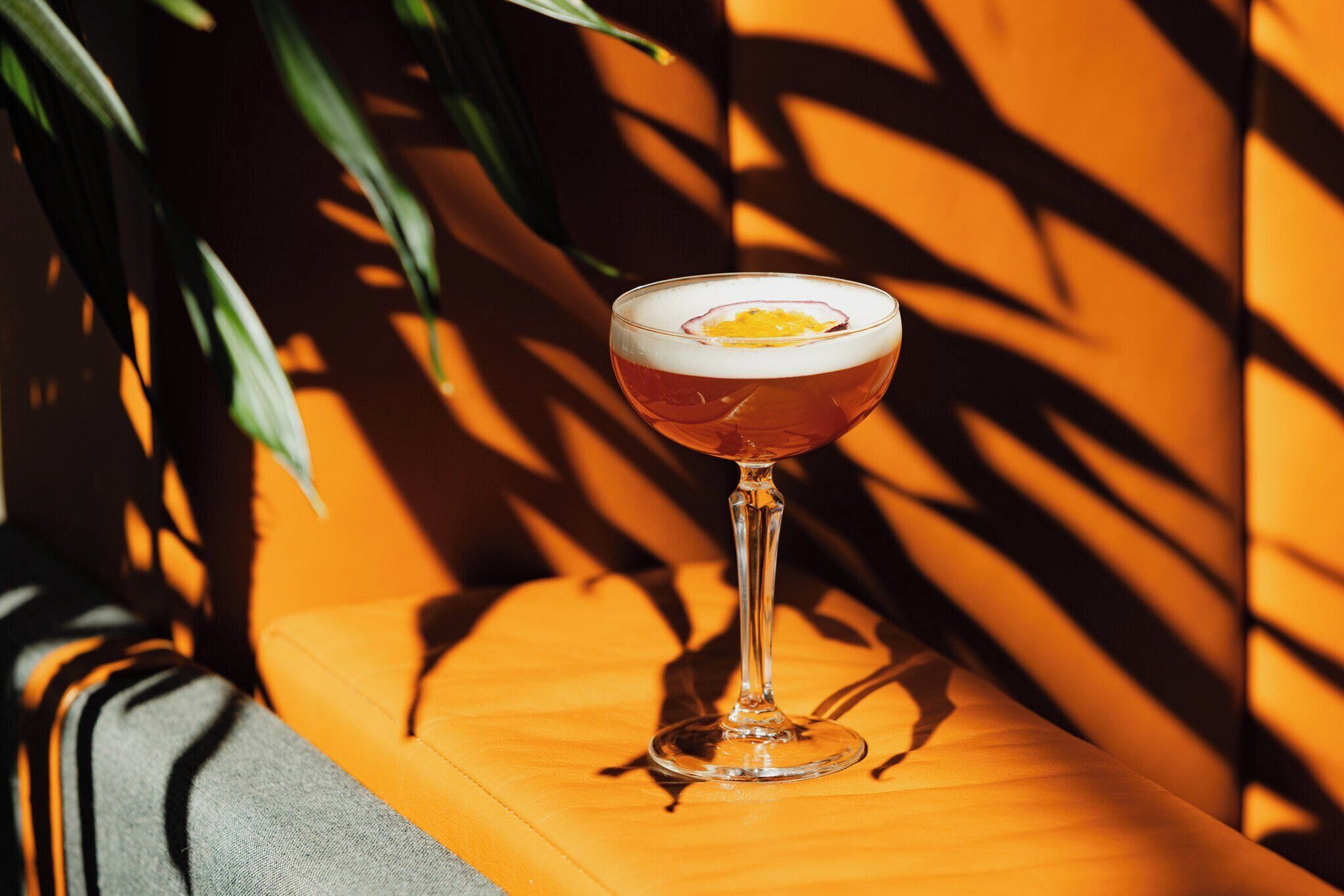 A cocktail glass with a garnish on a wooden surface.