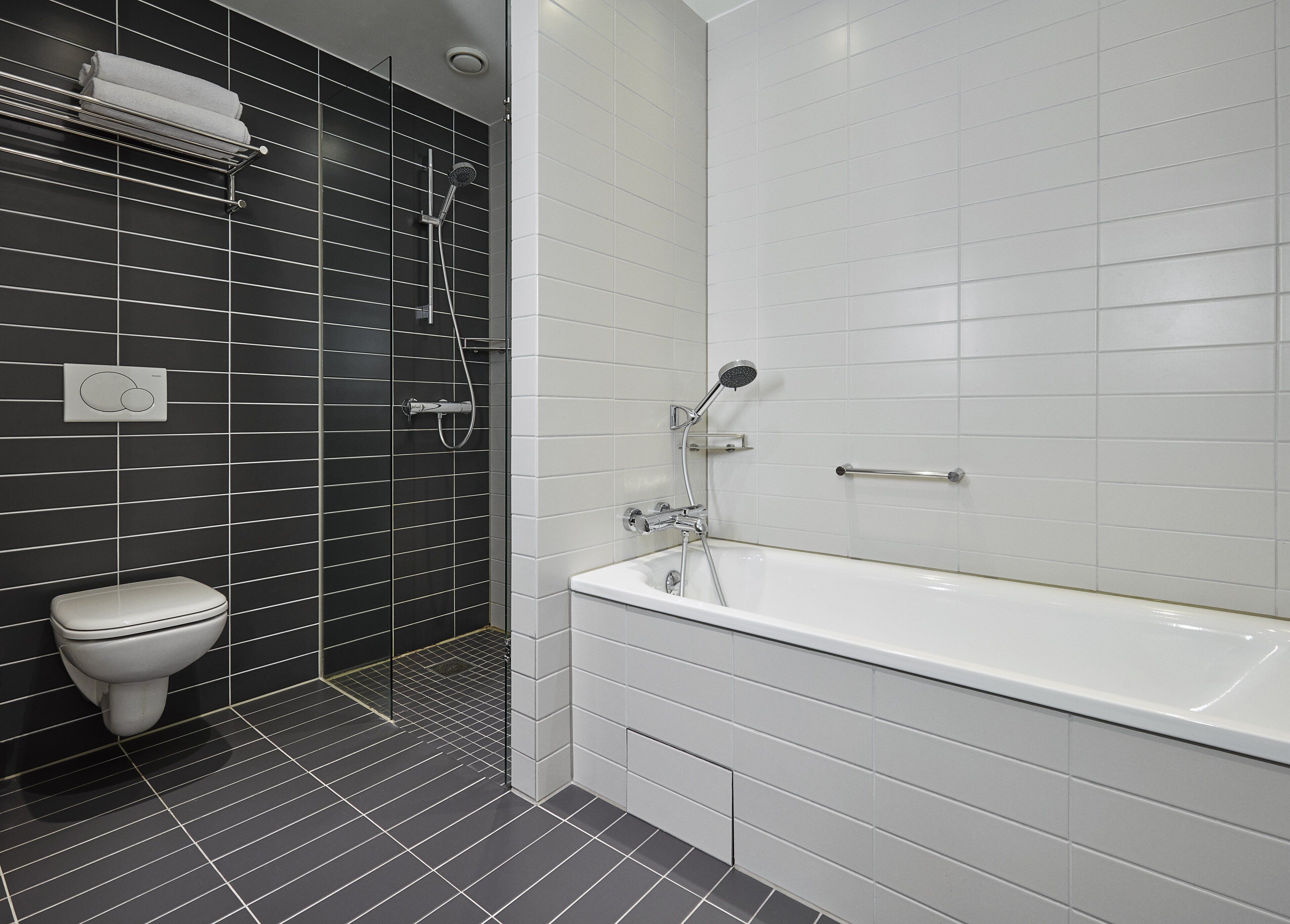 Un baño moderno con una bañera blanca, una zona de ducha separada y un inodoro.