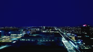 A nighttime aerial view of a cityscape with illuminated buildings and roads.