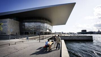 A waterfront building with a curved facade and a large overhanging roof.
