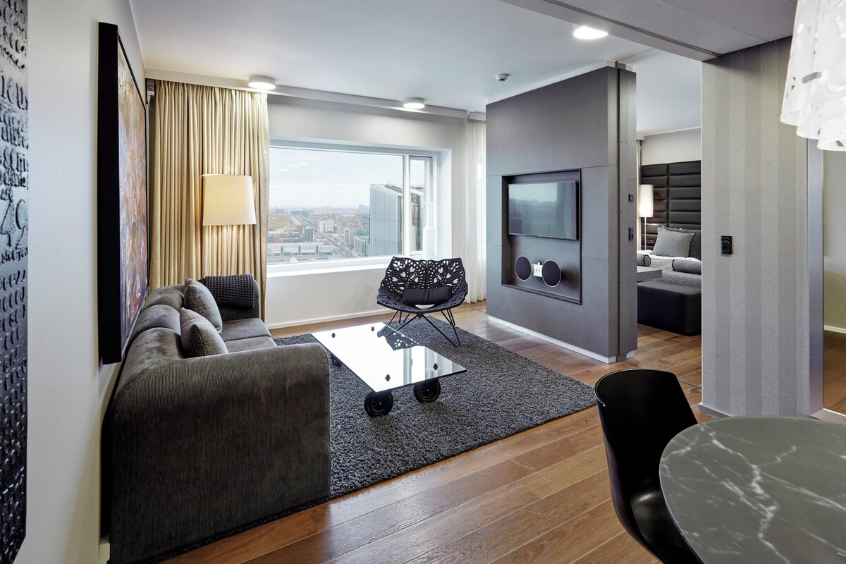 A modern living room with a sofa, a coffee table, and a TV mounted on the wall.