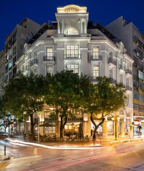 Un edificio histórico con una entrada destacada, ventanas amplias y un balcón con barandillas ornamentales.