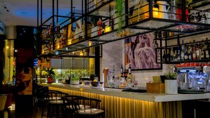 A bar area with multiple shelves of bottles, a bar counter, and seating. - Media One Hotel Dubai, WorldHotels Crafted (Dubai)