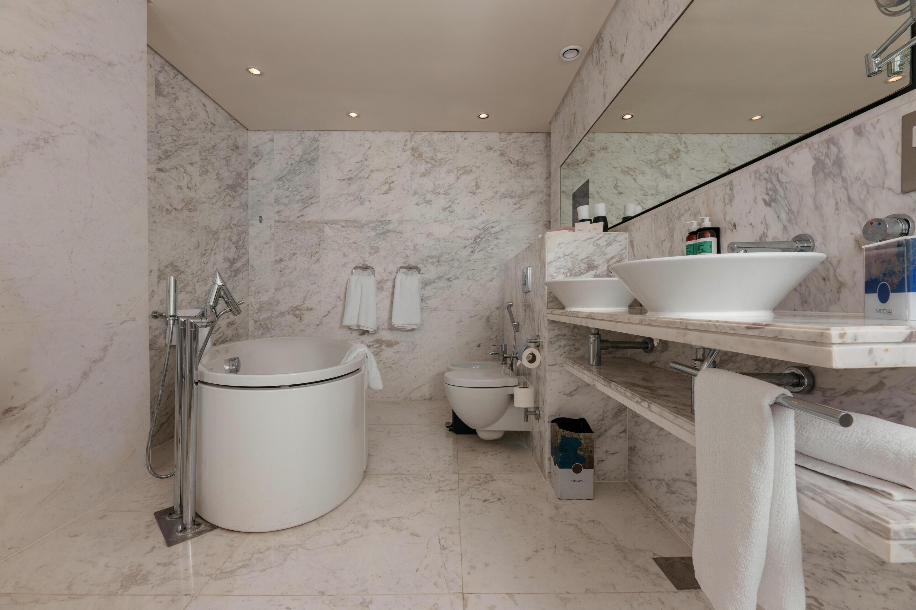 Et moderne badeværelse med badekar, toilet og håndvask.