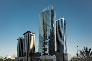 A modern high-rise building with reflective glass facade, surrounded by other buildings. - Media One Hotel Dubai, WorldHotels Crafted (Dubai)