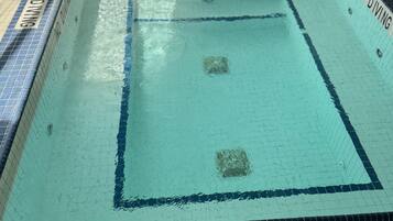A swimming pool with blue and white tiles, marked lanes, and a 'NO DIVING' sign.