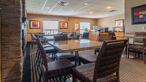 A restaurant with a stone wall, multiple tables, and chairs. - Best Western Plus South Edmonton Inn & Suites (Edmonton)
