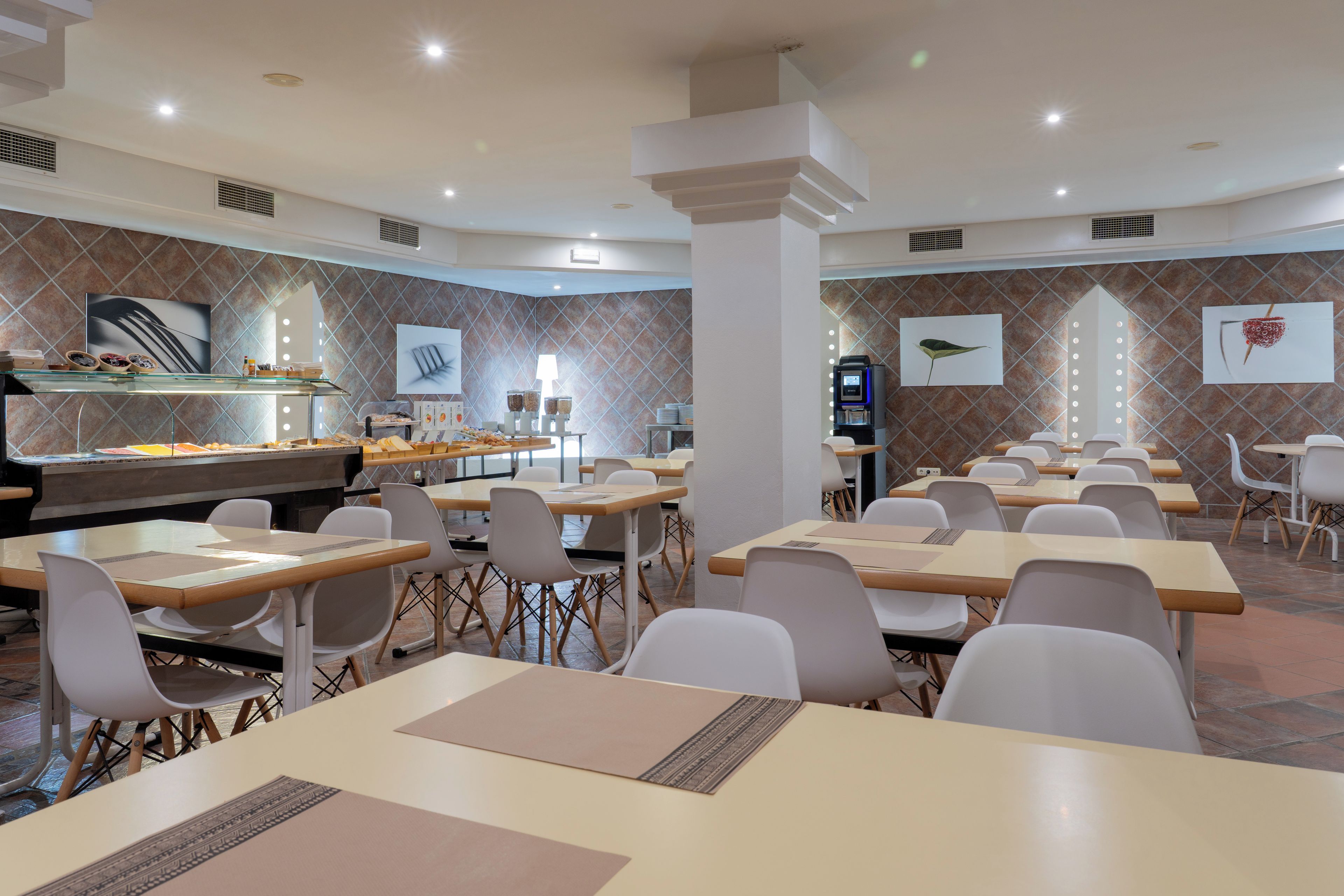 A modern dining area with multiple tables and chairs, a buffet counter, and a coffee machine.