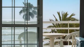 Ein Balkon mit Blick auf das Meer und Palmen.