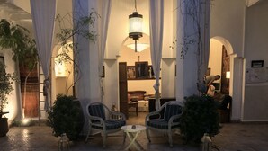 A courtyard with a pool, two wicker chairs, and a hanging lantern. - Riad Le Coq Berbere (Marrakech)