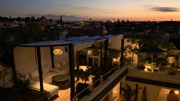 A modern residential building with a balcony, outdoor seating area, and a staircase leading to an upper level. - Riad Le Coq Berbere (Marrakech)