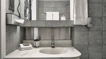 Un baño moderno con lavamanos de mármol, un perchero y una zona de ducha.