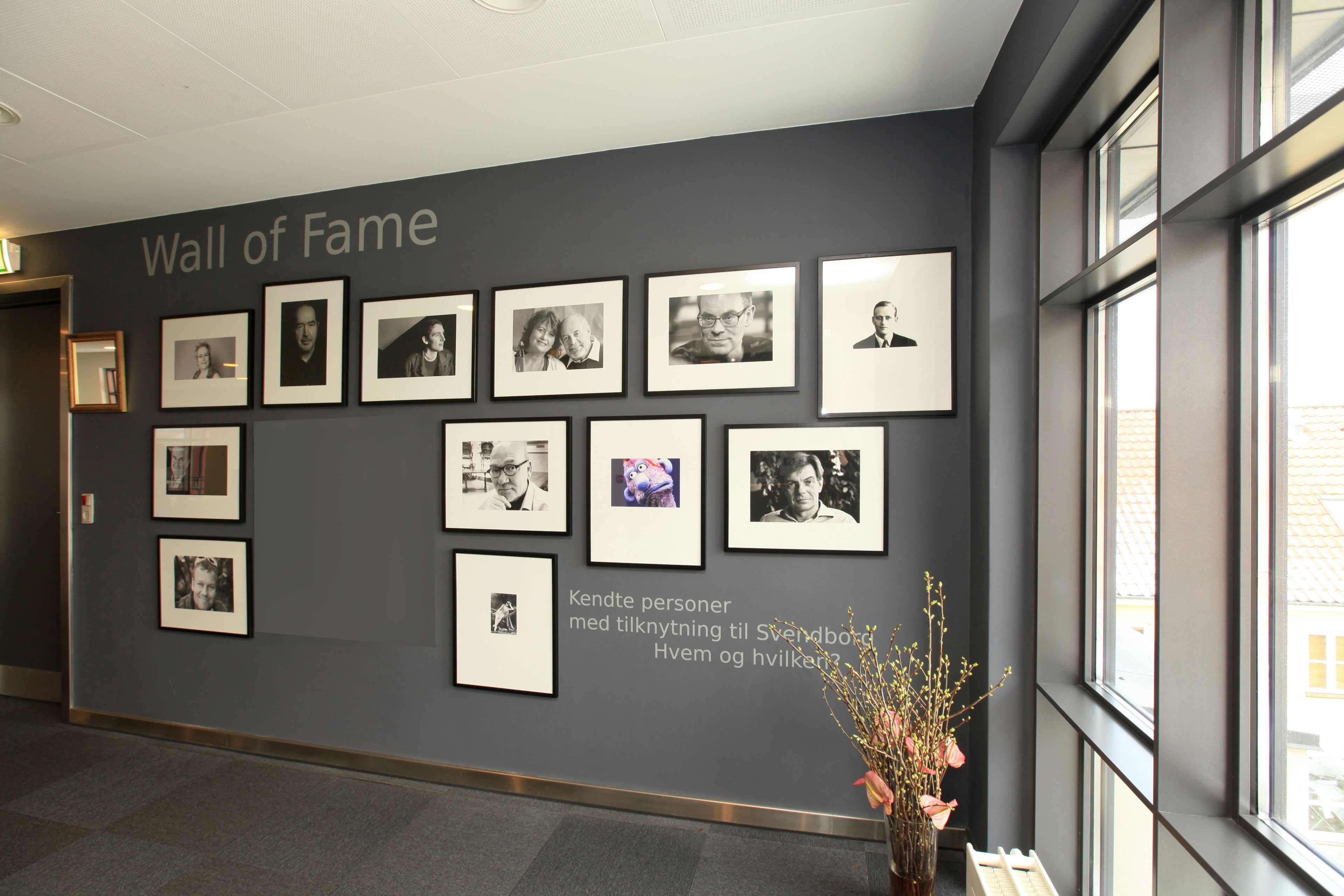 Un pasillo con un 'Wall of Fame' que muestra fotografías enmarcadas en la pared.