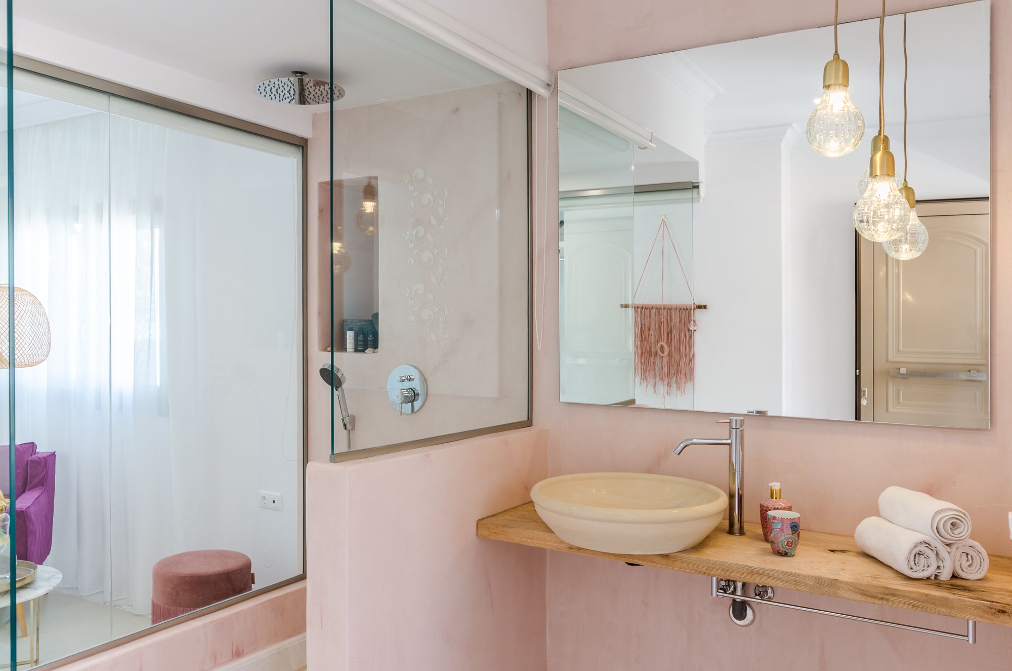 Un baño moderno con un espejo grande, un lavabo y una ducha.