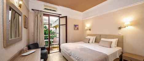 Ein Hotelzimmer mit Bett, Nachttisch, Stuhl und Schreibtisch mit Lampe.