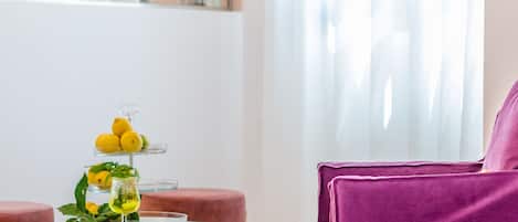 Una sala de estar moderna con una mesa redonda, un sillón púrpura y una lámpara colgante.