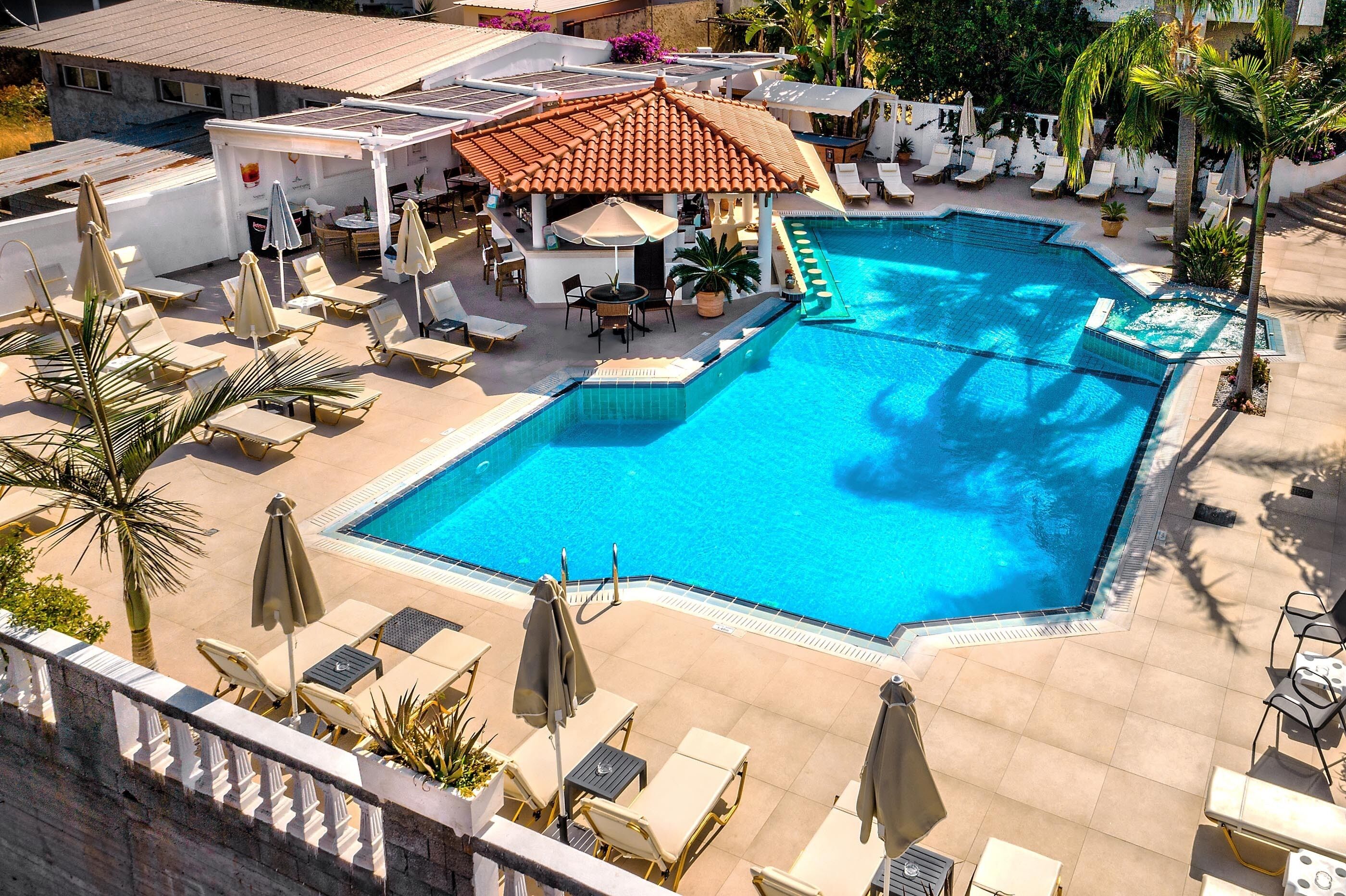 Alberca al aire libre, sombrillas en la alberca y camastros 