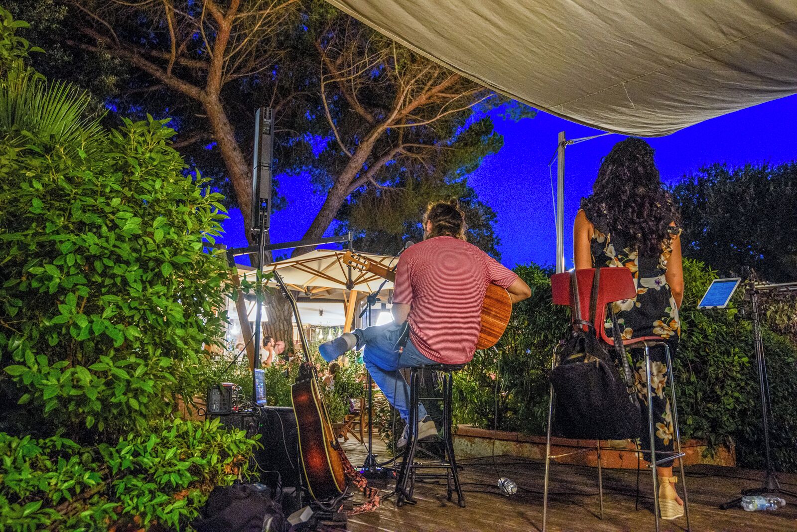 An outdoor music performance area with a stage, musical instruments, and a canopy.
