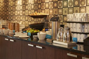 A buffet setup with various food items and beverages, including fruits, cereals, and coffee machines. - Scandic Hakaniemi (Helsinki)