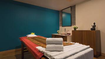 Relax in this serene spa room with a massage table, cabinet, and Buddha statue.