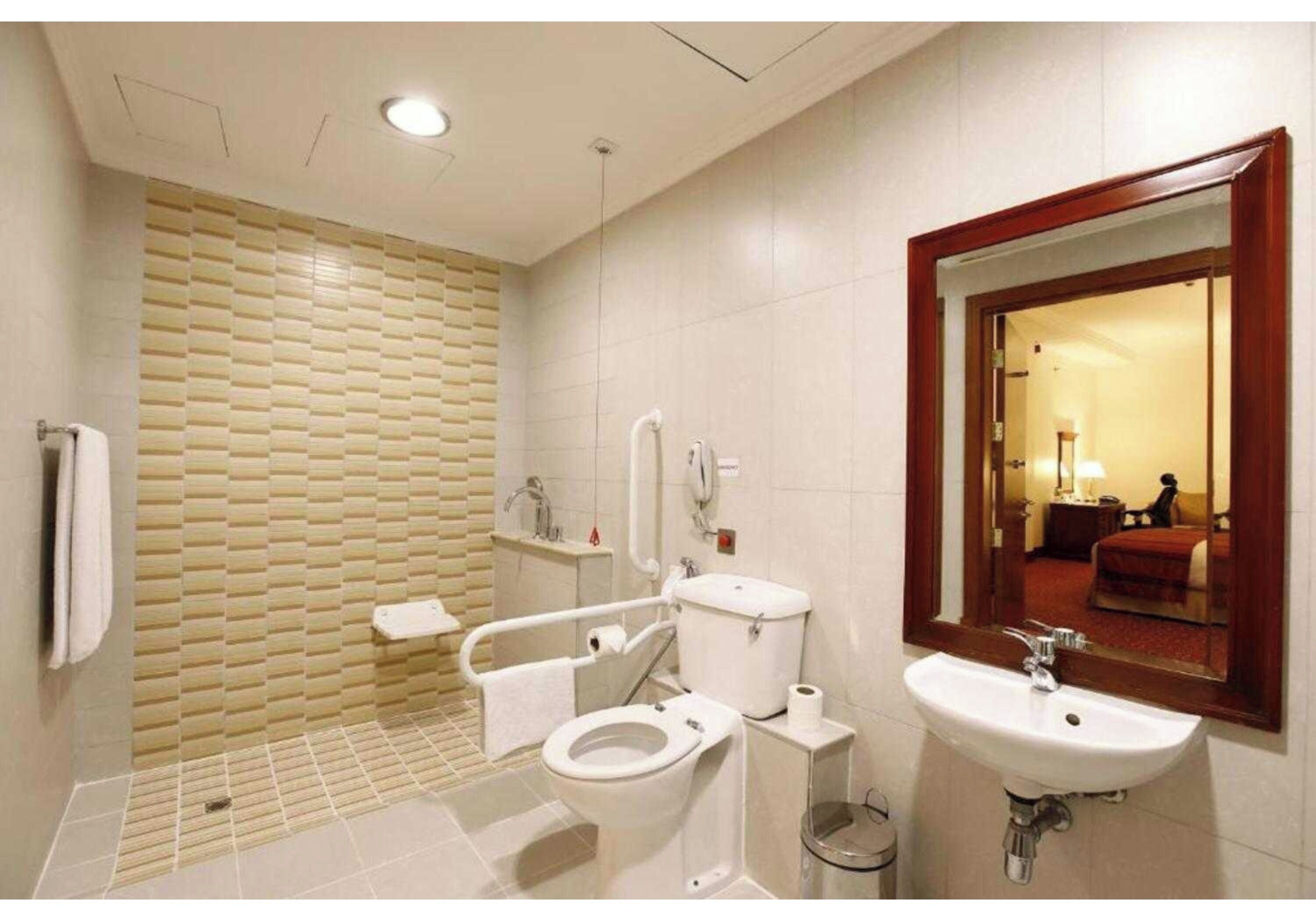 A modern bathroom with a toilet, sink, and shower.