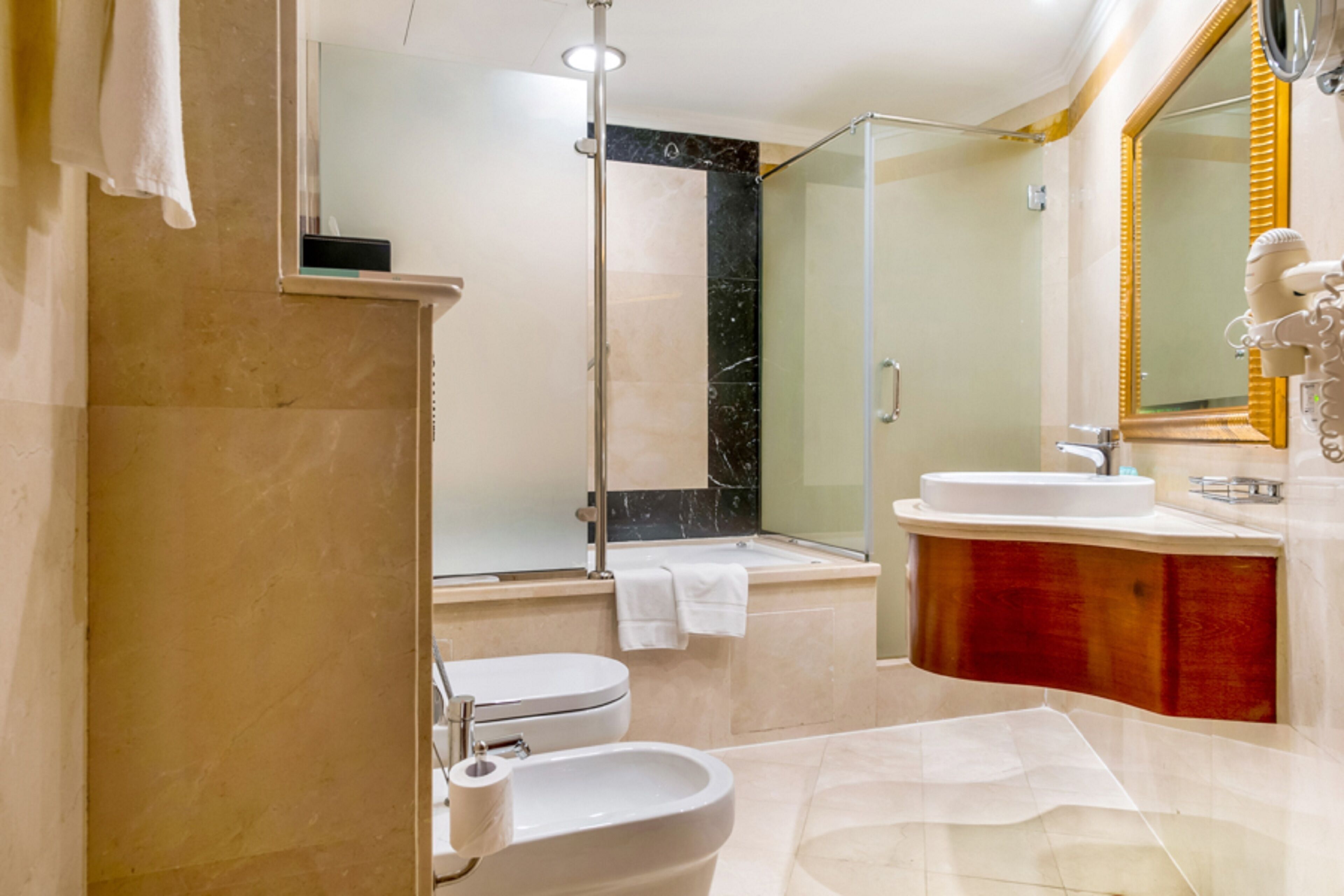 Un baño moderno con inodoro, lavamanos y zona de ducha.