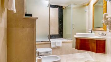Un baño moderno con inodoro, lavamanos y zona de ducha.