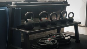 A weightlifting bench with kettlebells and weight plates. - Ker Recoleta Hotel (Buenos Aires)