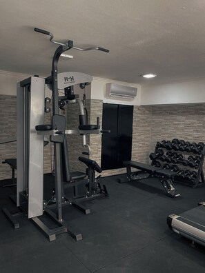 A gym with exercise equipment, a bench, and a rack of dumbbells. - Ker Recoleta Hotel (Buenos Aires)