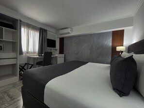 A hotel room with a bed, desk, chair, and built-in TV. - Ker Recoleta Hotel (Buenos Aires)