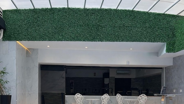 An indoor pool with clear water, surrounded by white chairs and a green wall. - Ker Recoleta Hotel (Buenos Aires)