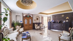 Un vaste salon agrémenté de meubles décoratifs, un comptoir d’accueil et une grande porte en bois.